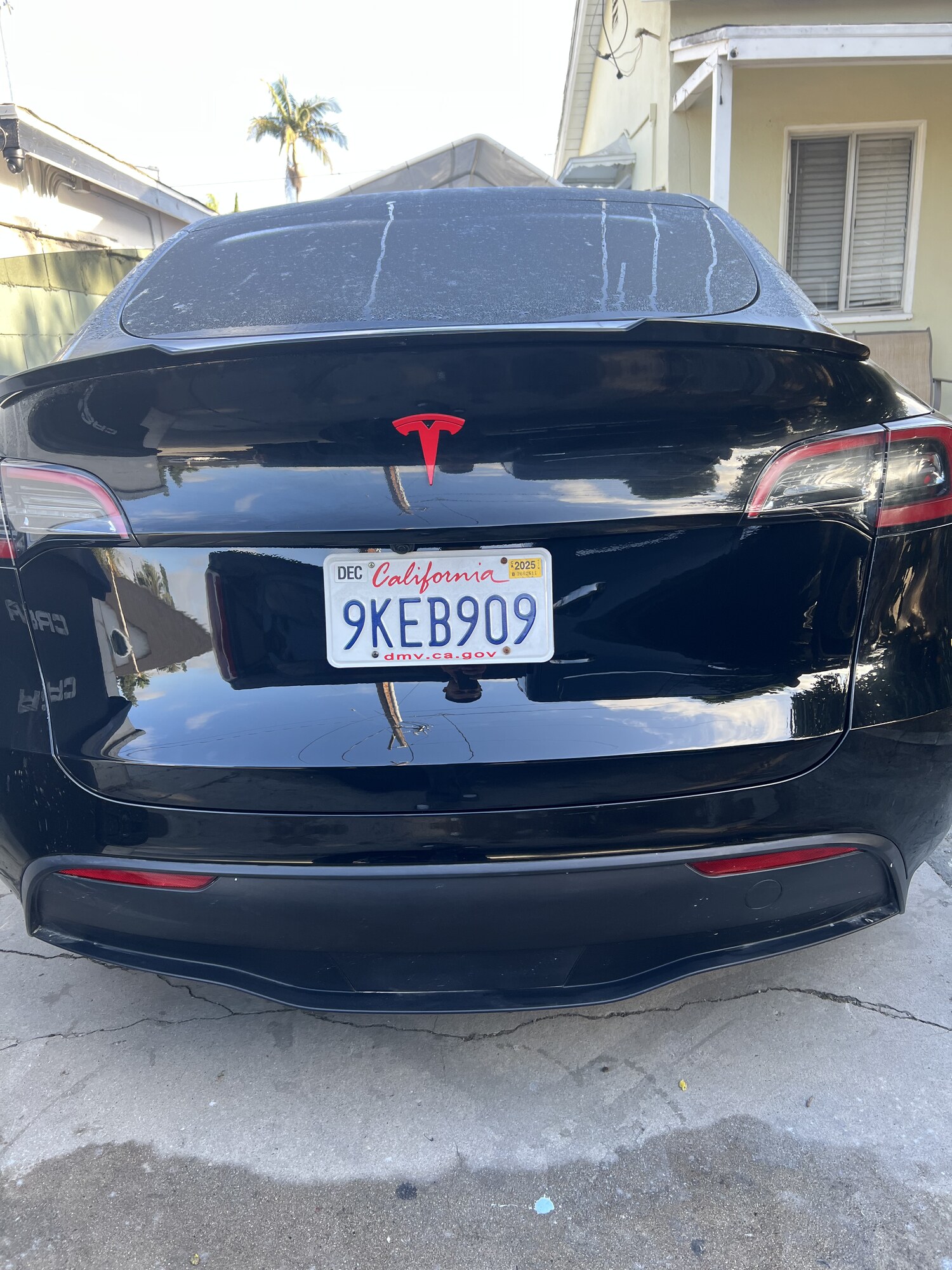 Tesla Model Y trunk dent pulled and refinished — before